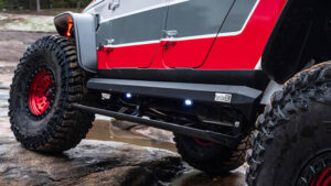 A jeep is parked on a rock in a river.